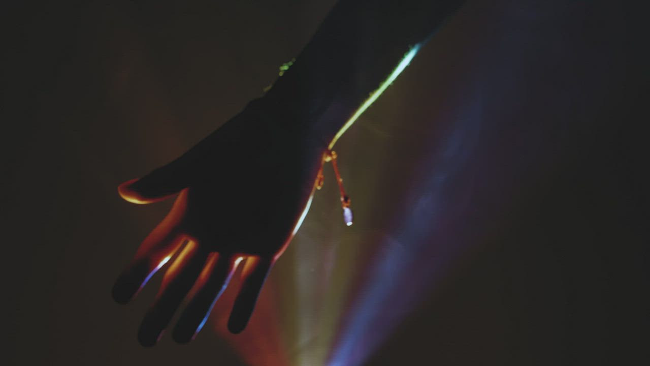 一个人的手在黑暗中透过彩色灯光视频模板素材完整版免费下载